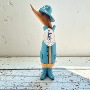 Handcarved bamboo root duck figurine wearing a blue coat and hat.