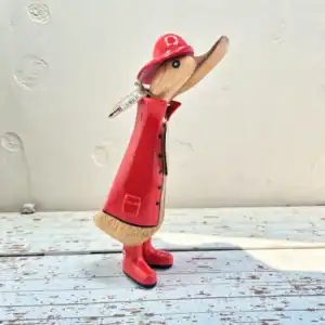 Handcarved bamboo root duck figurine wearing a red raincoat and hat.